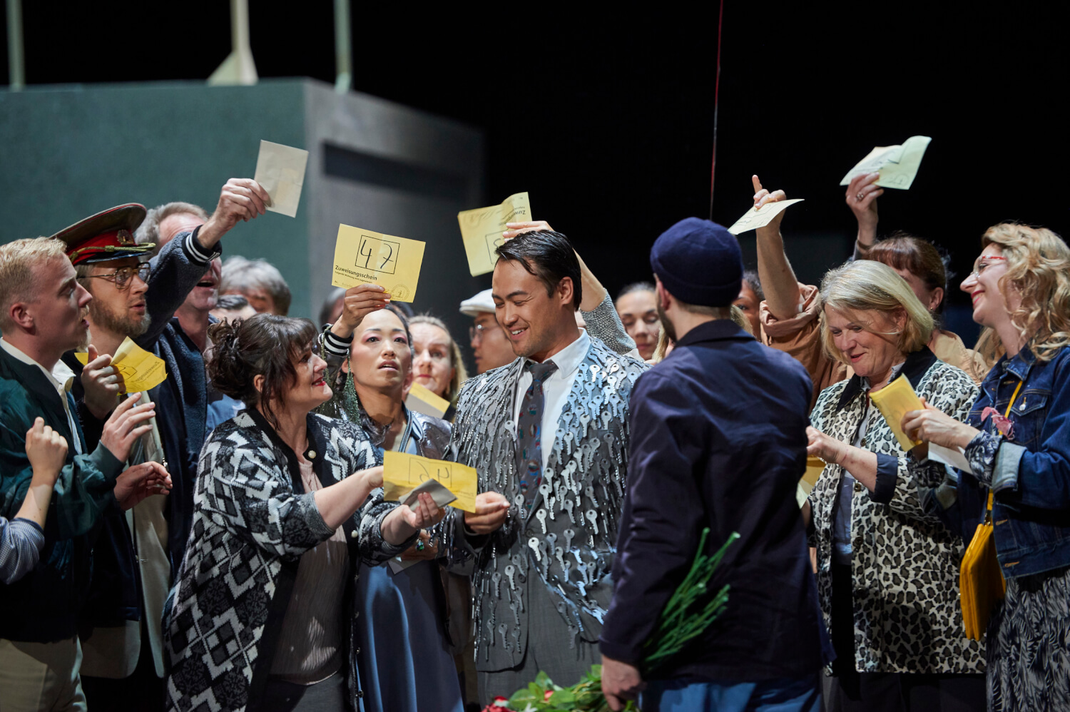 Eugene Villanueva als beflissener Hausmeister und der Chor des Staatstheaters in "Moskau, Tscherjomuschki" in Braunschweig