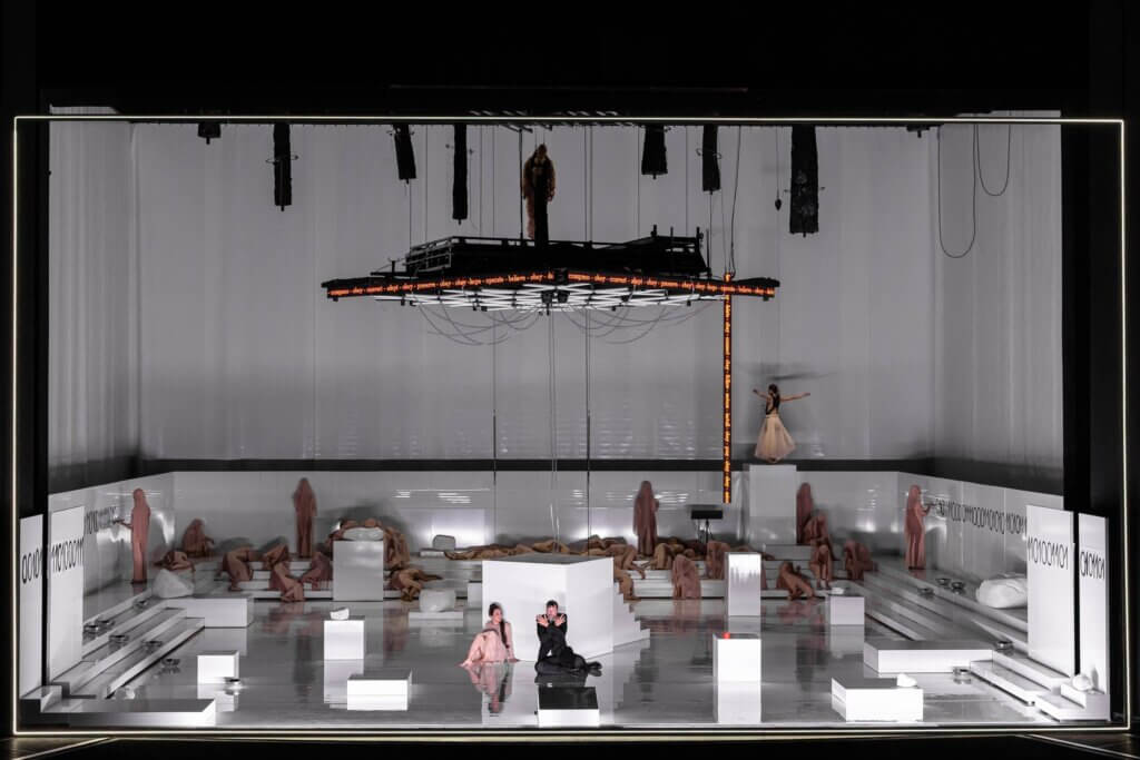 eine klinisch weiße Bühne mit verschiedenen Darsteller:innen