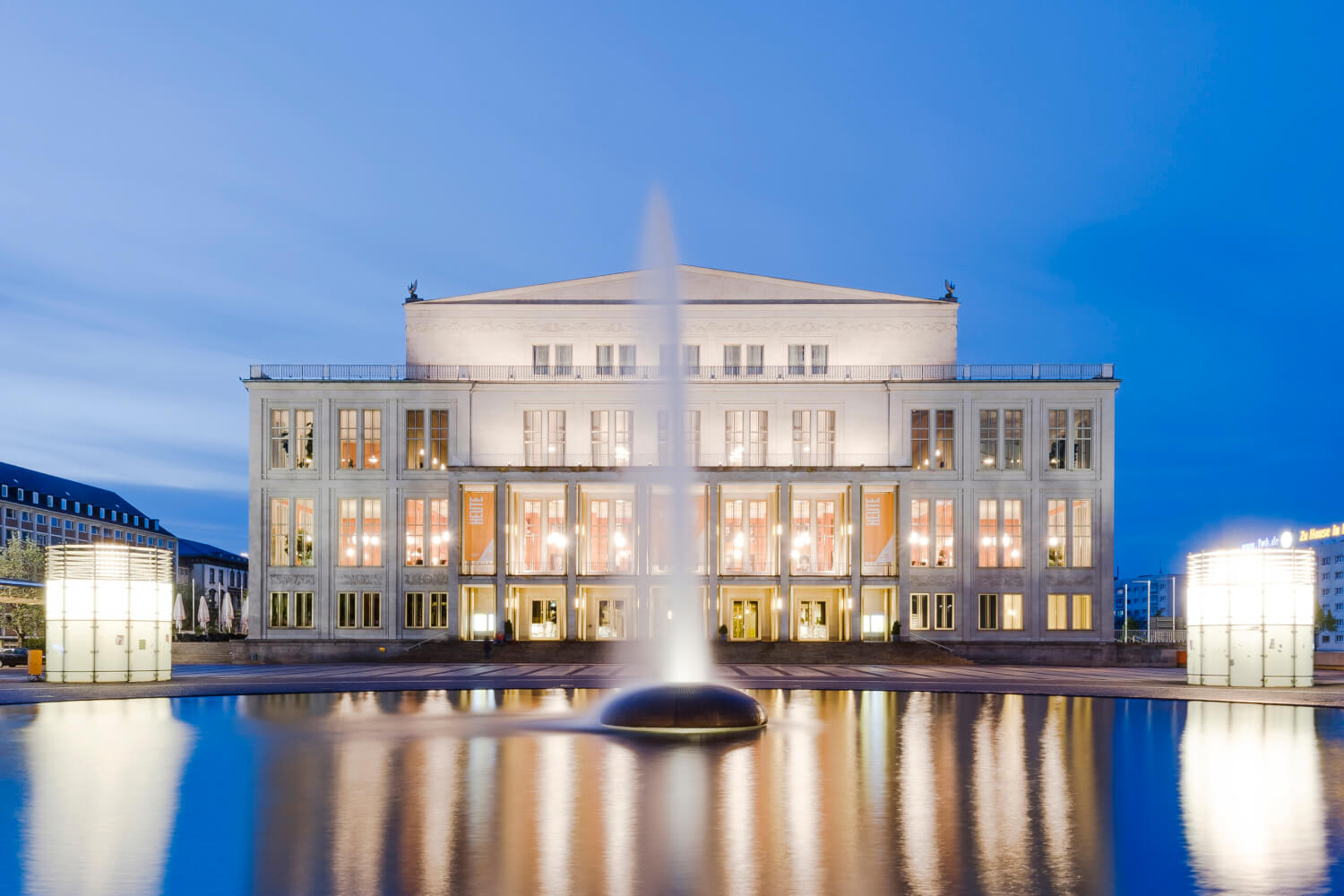 oper_leipzig_opernhaus_augustusplatz_quer_kirsten_nijhof__1 Zu sehen ist die Oper Leipzig. Im Vordergrund der Augustusplatz mit Wasserfontäne.