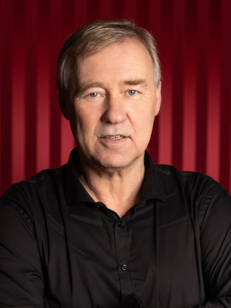 Zu sehen ist Jens Neundorff von Enzberg, Intendant des Staatstheater Meiningen, vor einem roten Samtvorhang