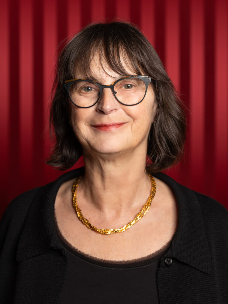Zu sehen ist Susanne Tenner-Ketzer, Leiterin Junge Musik am Staatstheater Meiningen, vor einem roten Vorhang