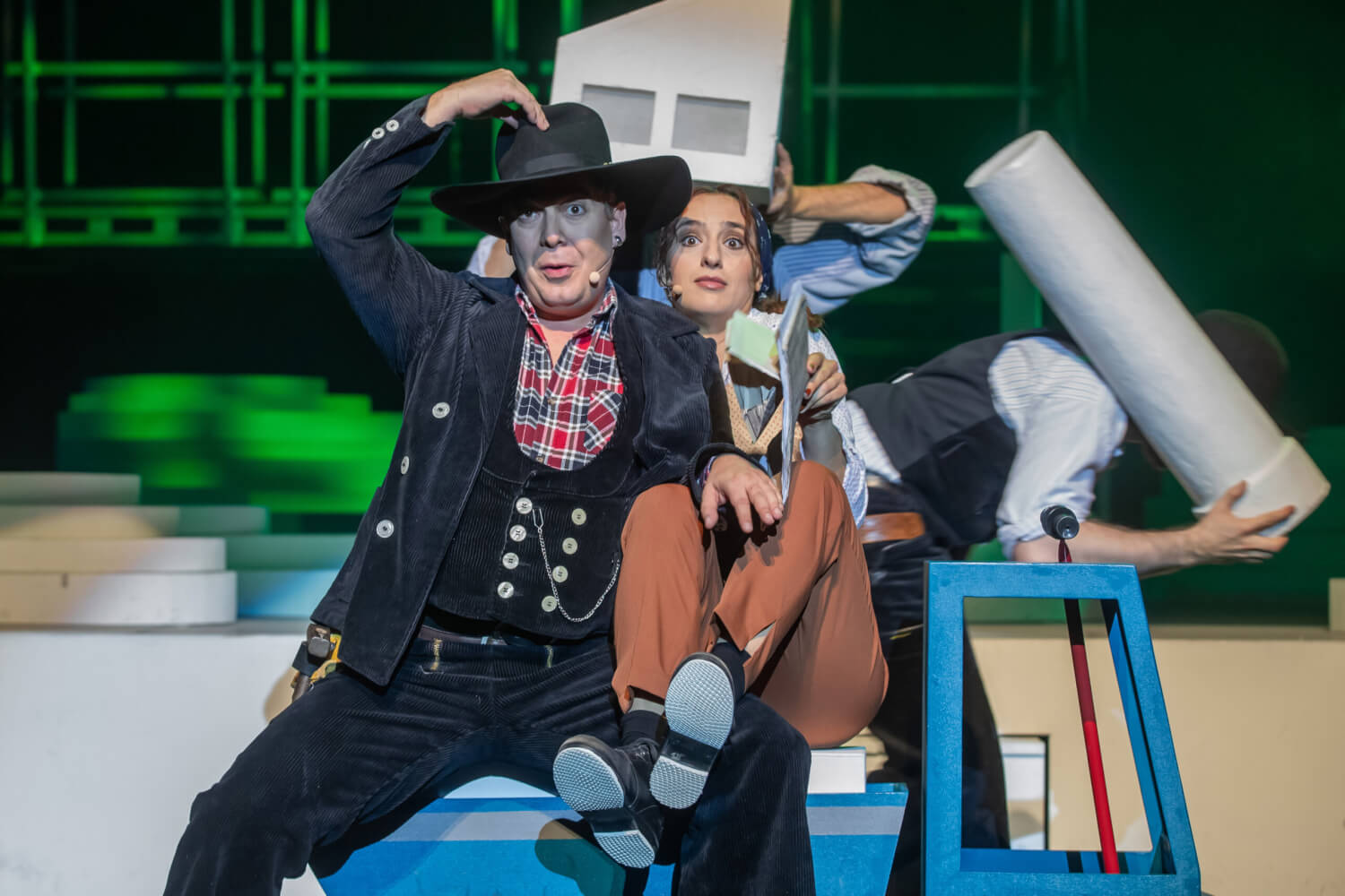 Fabian Ranglack und Antonia Schwingel sitzen eng bei einander auf der Ladefläche eines Spielzeug-LKWs. Beide tragen KLeidung, die an Western-Filme angelehnt ist.