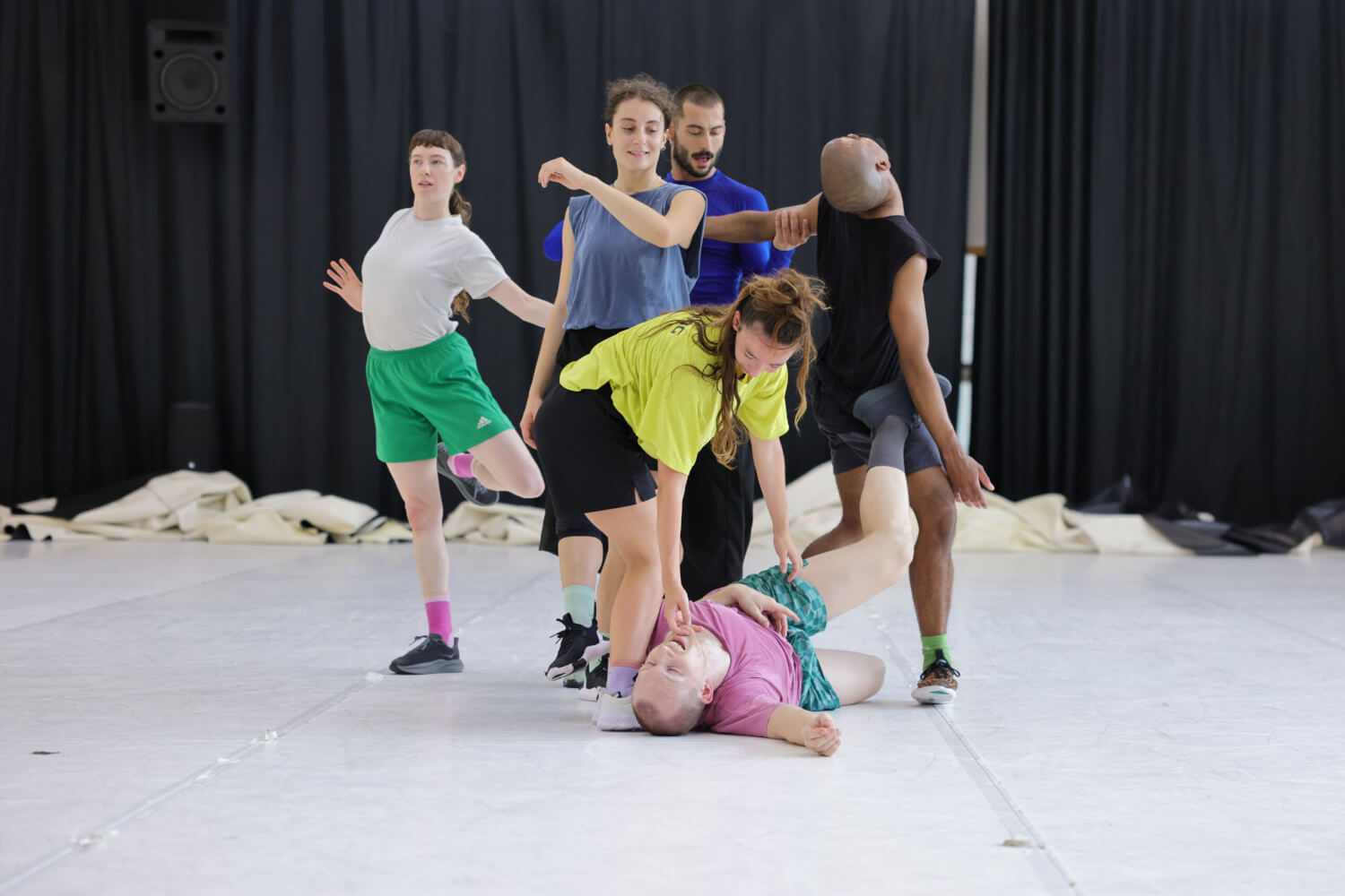 Probefoto von „Join“ von Ioannis Mandafounis. Ein Tänzer liegt auf dem Boden. Eine andere Tänzerin schaut ihn von oben an und berührt ihn am Mund. Im Hintergrund zwei Tänzerinnen und zwei Tänzer.