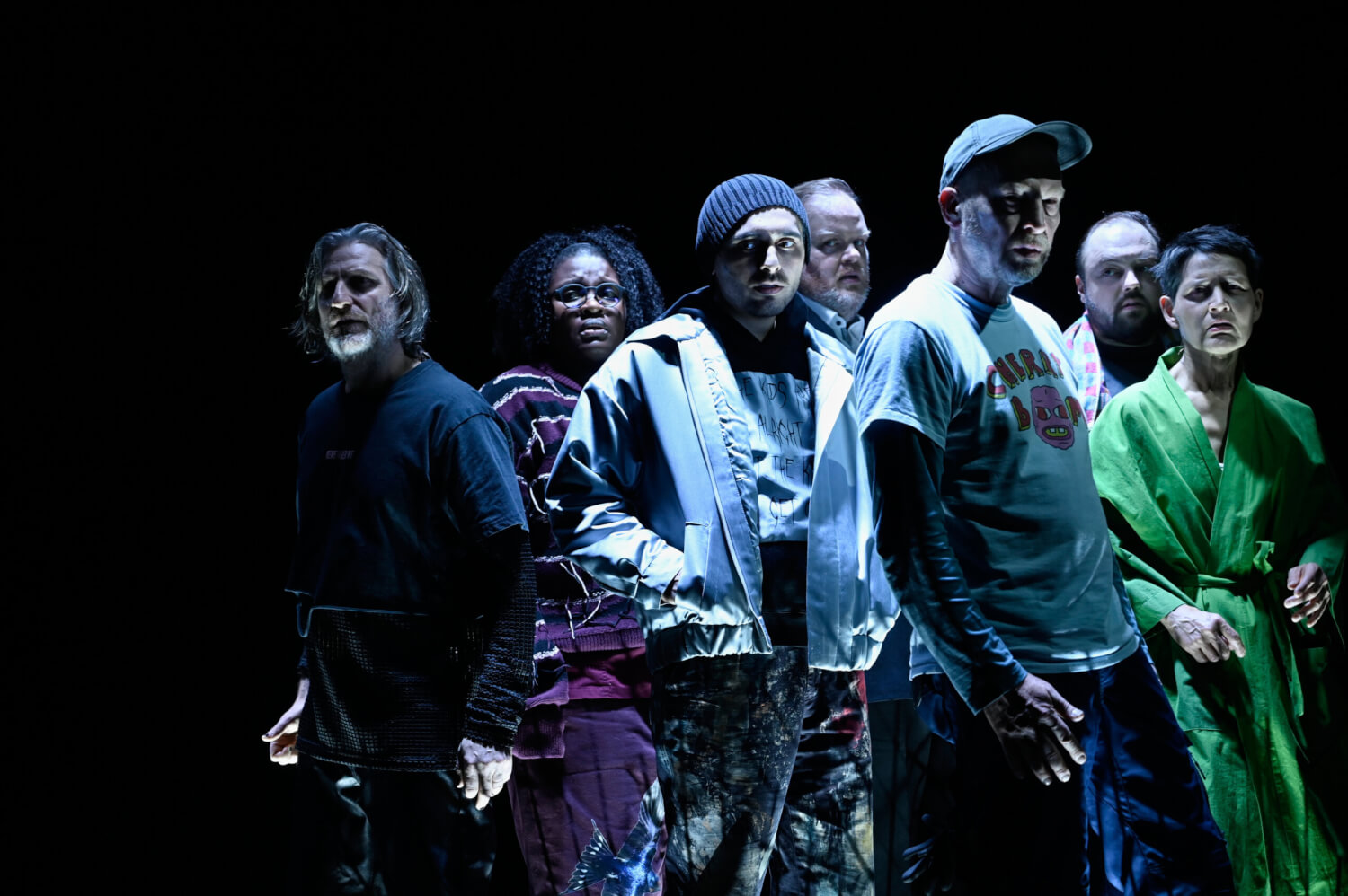 Das Ensemble steht gemeinsam eng bei einander. Trotzdem steht jede Person für sich selbst, wirkt einsam.