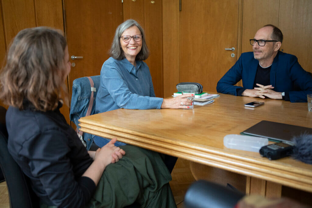Drei Personen an einem Tisch beim Interview
