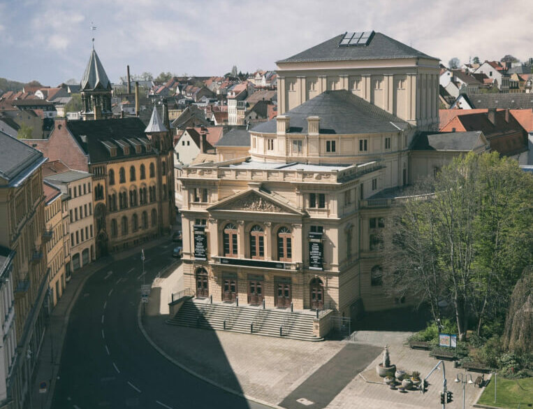 Das Theater Altenburg in der Totalen fotografiert. Im Vordergrund des Gebäudes ein Vorplatz und eine Straße.