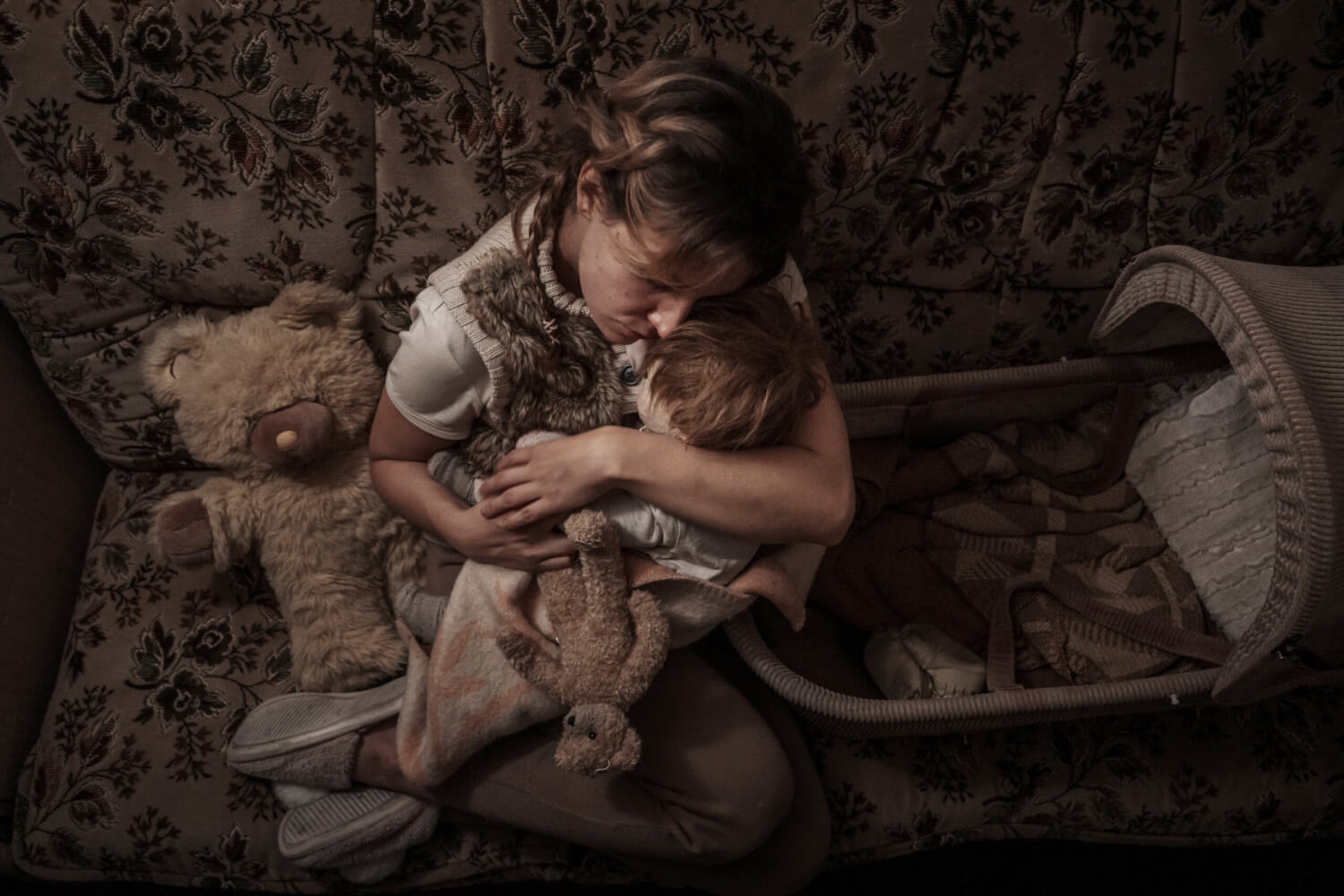 „Das 13. Jahr“ von 2023 am Deutschen Schauspielhaus Hamburg. Eine junge Frau hält eine Puppe und einen kleinen Teddybär in ihren Armen. Daneben ein großer Teddybär und eine Wiege.