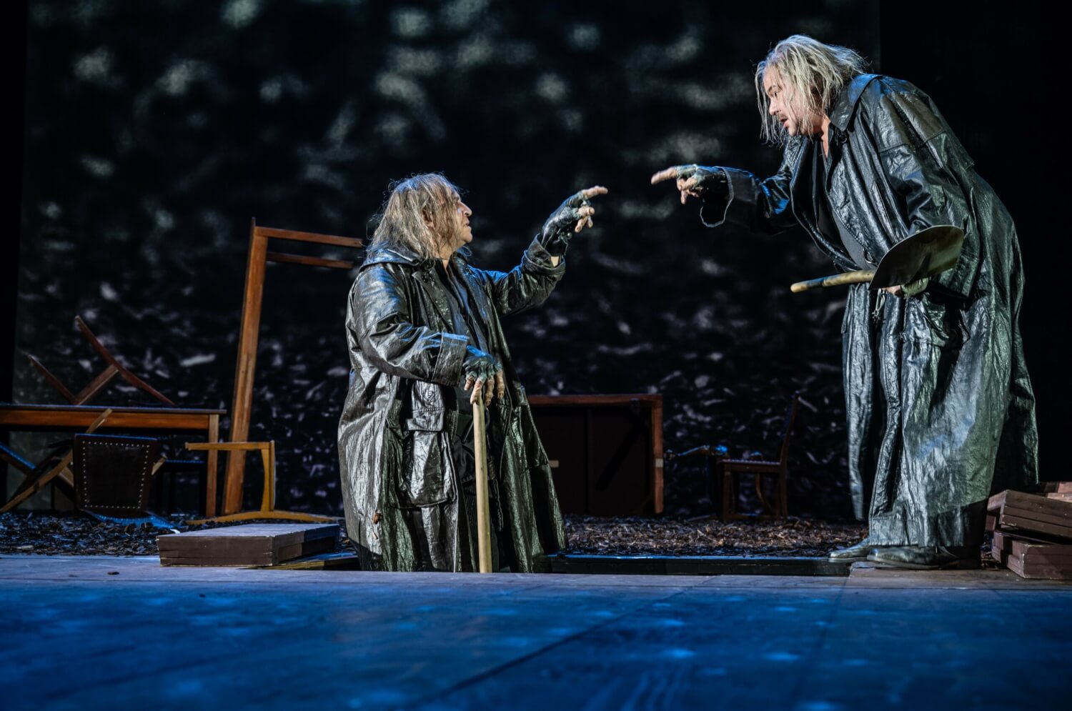 Aufführungsfoto von „Hamlet“ von William Shakespeare am Schauspiel Stuttgart. Die zwei Totengräber schauen sich an und zeigen mit dem Finger aufeinander.