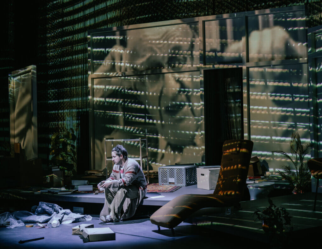 Schauspieler Dimitrji Schaad sitzt vor der Video-Wand in Yael Ronens Stück „Sabotage“ an der Schaubühne Berlin