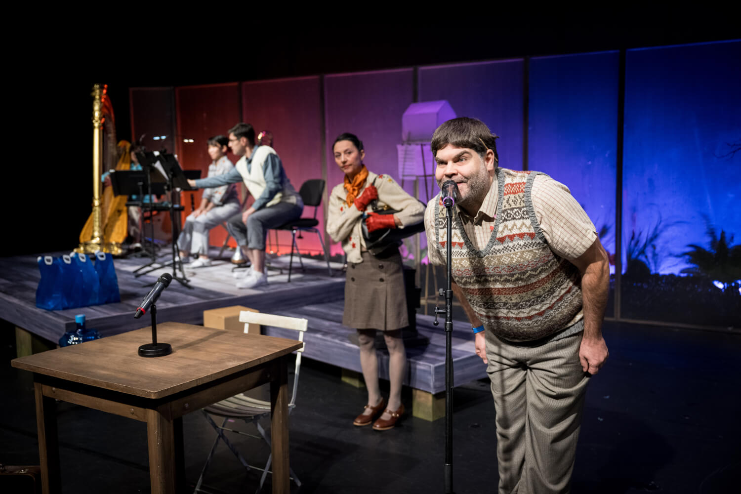 links drei Musiker:innen, rechts daneben zwei Darsteller:innen