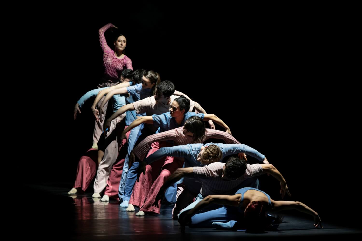 „Next Wave“: „Ephemerus“ von Ana Isabel Casquilho am Landestheater Eisenach. Neun Tänzerinnen und Tänzer beugen hintereinander aufgereiht ihre Arme nach Außen. Alle schauen nach links.