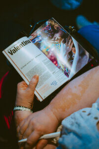 Spielzeitheft am Théâtre national de Strasbourg. Eine Frau hat ein Spielzeitheft auf ihrem Schoß.