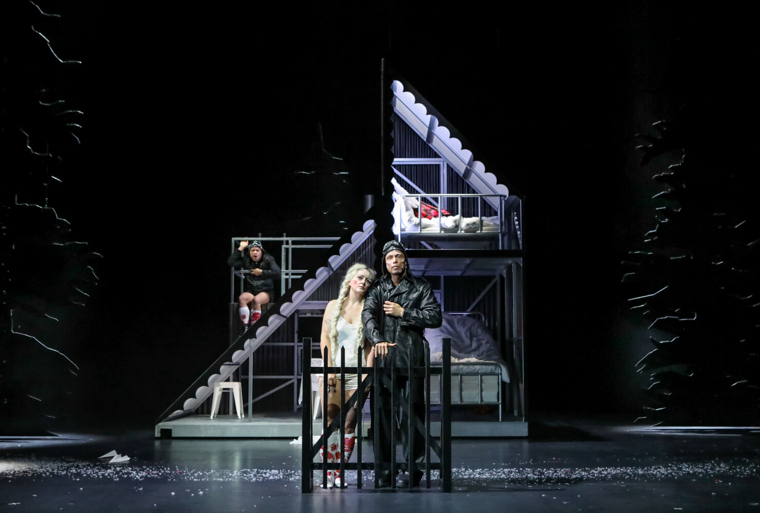 Peter steht am Zaun. Seine Frau neben ihm, ihr Kopf an seiner Schulter. Im Hintergrund steht das Haus.