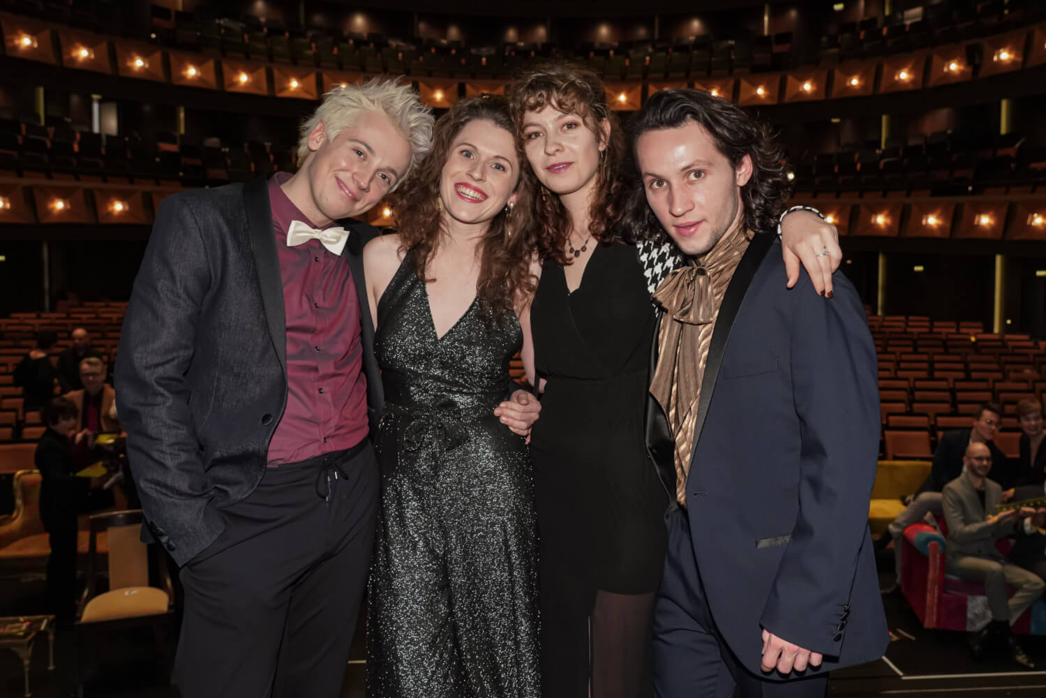 Das punktlive-Team bei der FAUST-Verleihung in der Oper Hannover. Zwei Männer und zwei Frauen lächeln in die Kamera. Im Hintergrund der Zuschauersaal der Oper.