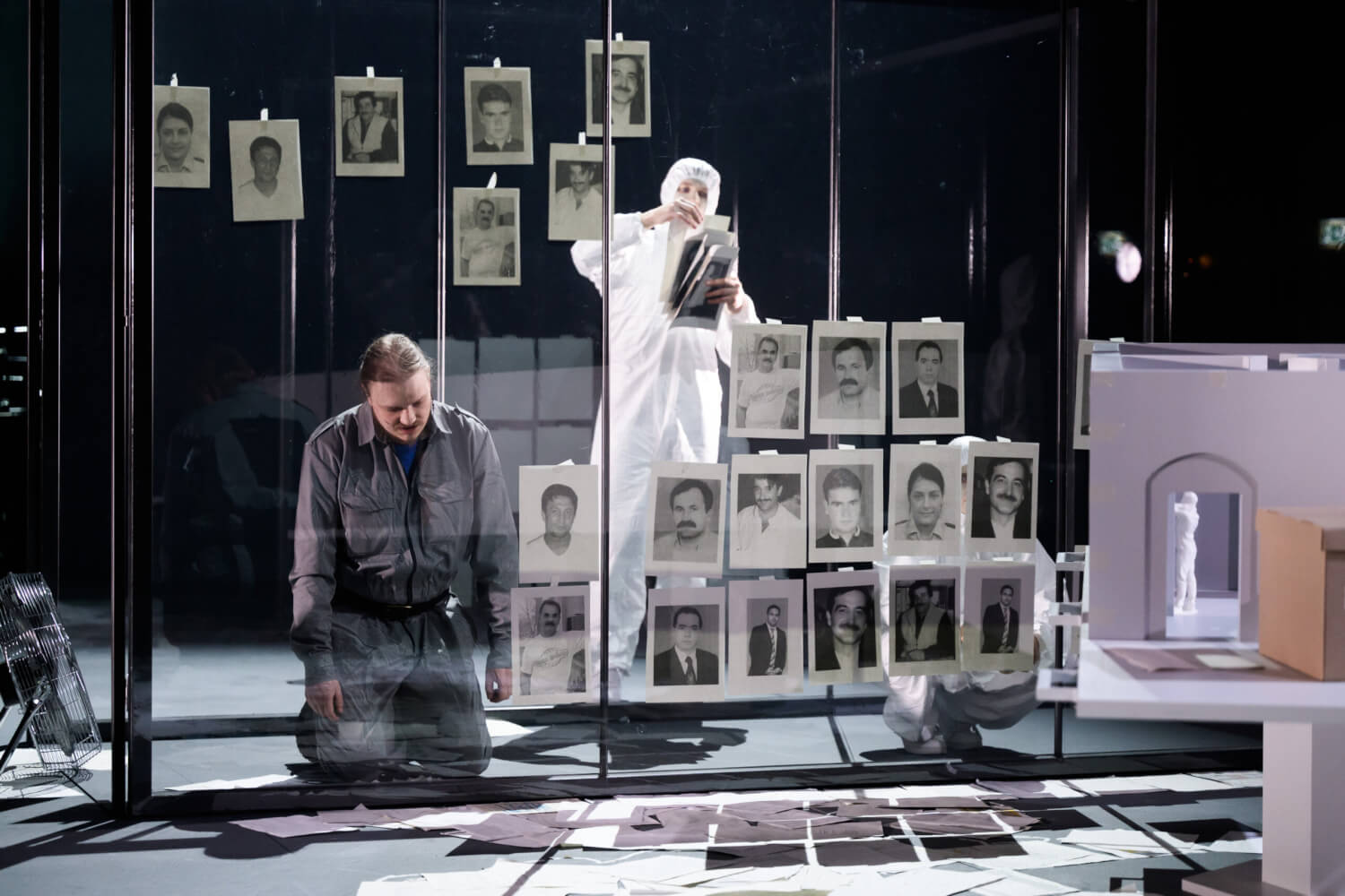 Joel Andreasson kniet vor einer durchsichtigen Wand. Daran klebt jemand aus der Statisterie Porträt-Bilder.