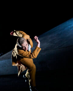 eine Darstellerin in einer rennenden Bewegung eingefangen auf der Bühne