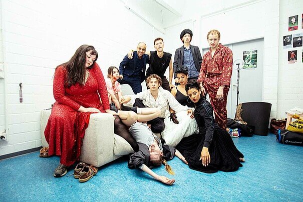 Jahrgang 2022 der Ausbildung für zeitgenössisches Theater an der Universität der Künste. Zehn Männer und Frauen auf und neben einem Sofa versammelt in unterschiedlichen Posen.