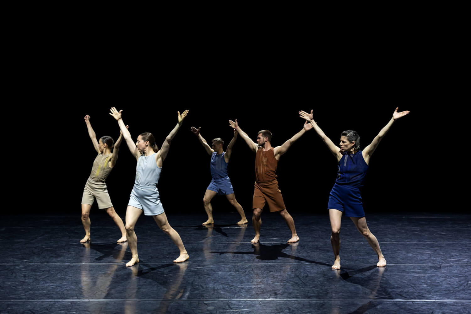 Aufführungsfoto von Dance On Ensemble mit „A Suite of Dances“ von Noa Eshkol. Fünf Tänzer:innen stehen versetzt und strecken ihre Arme weit auseinander.