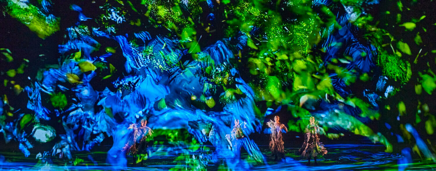 eine Bühne mit blau und grün bestrahltem Gaze Vorhang