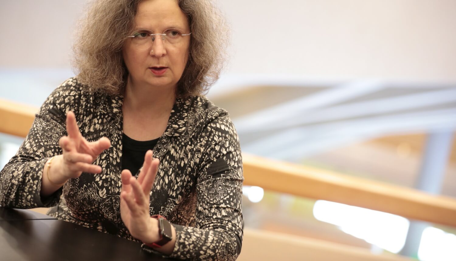 Claudia Schmitz während des Interviews, gestikulierend, konzentriert nach rechts blickend.