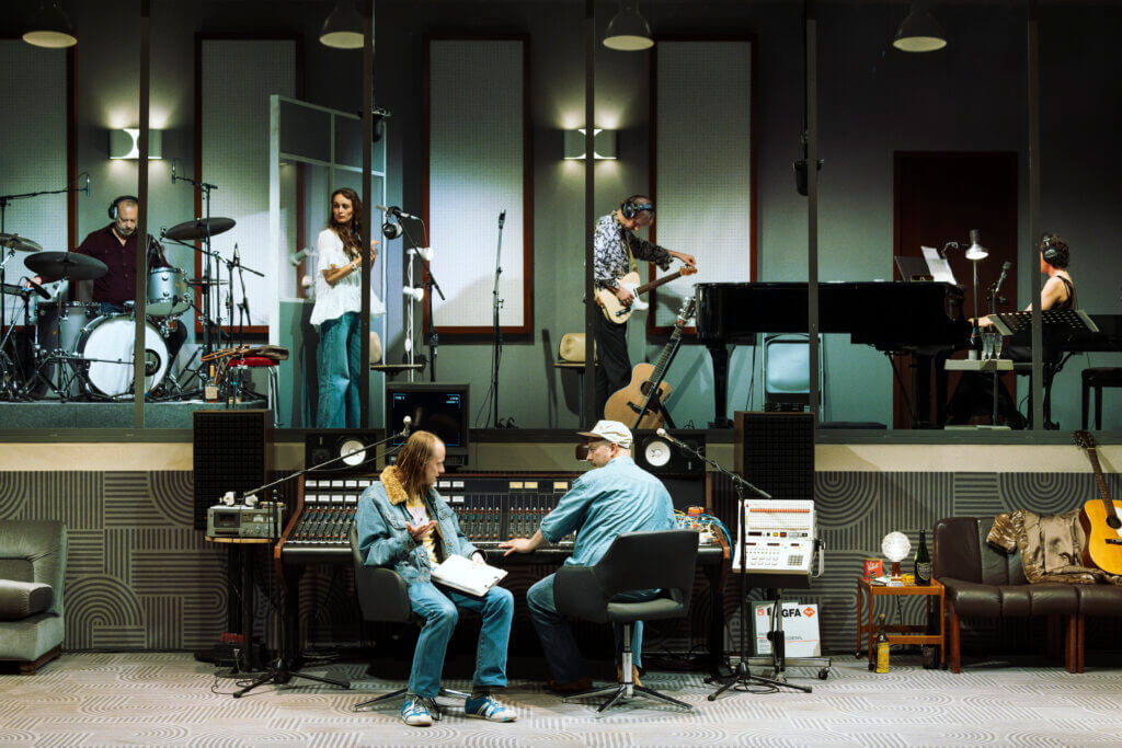 Aufführungsfoto von „Stereophonic“ an der Schaubühne. Ein Tonstudio auf zwei Ebenen. Unten sitzen zwei Männer am Mischpult.